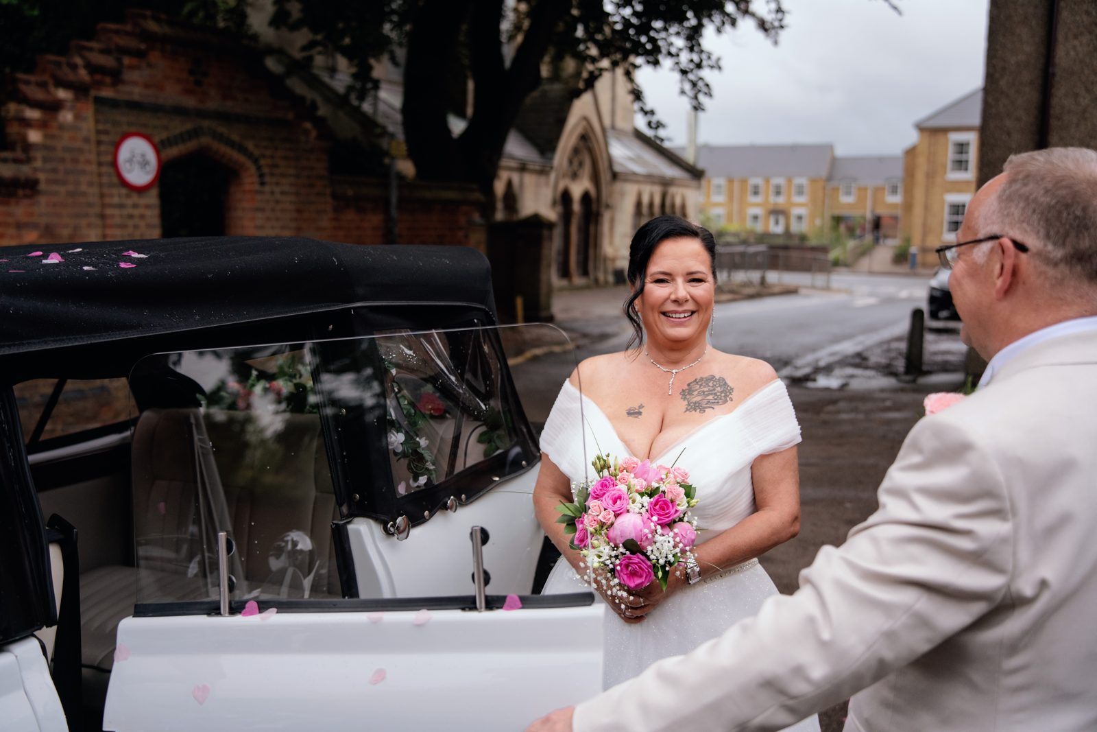 Bride arriving and greeted beside the wedding car