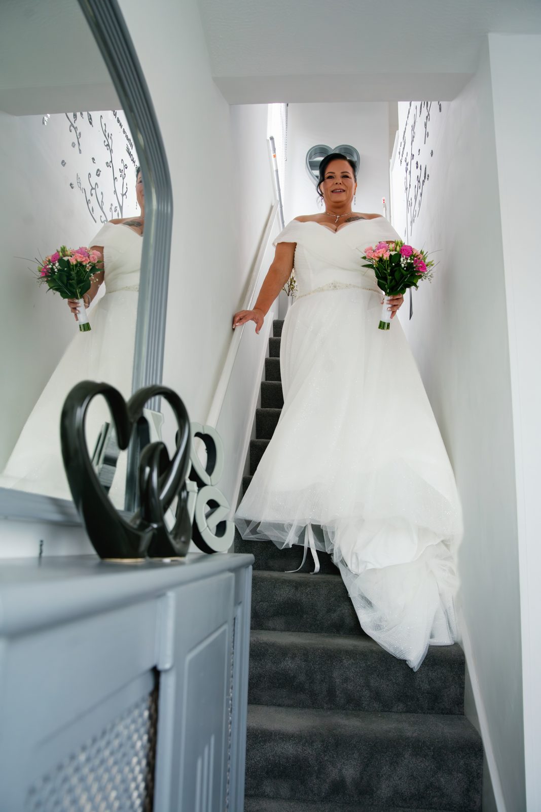 Bride descending the staircase with her bouquet