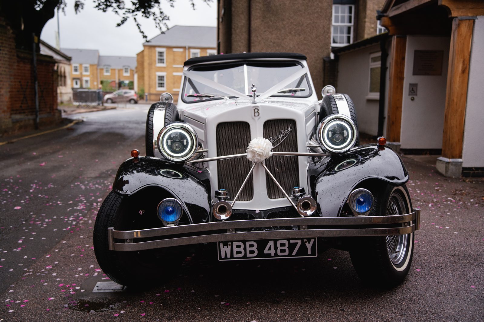 Classic vintage Beauford wedding car adorned with ribbons